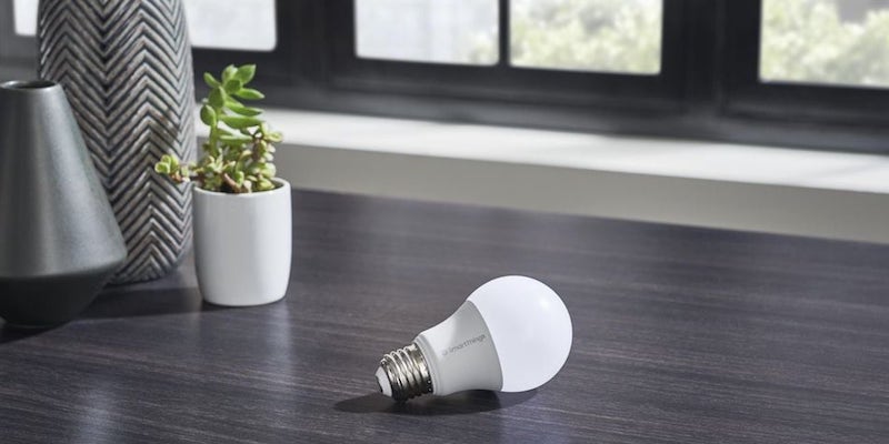 A cool gadgets 2019 smart lightbulb on a table next to a vase.