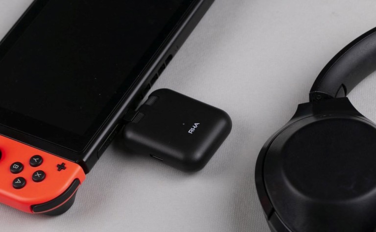 A small, black smart travel gadget is plugged into a small electronic device.