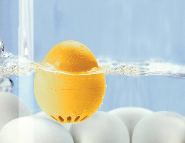 A yellow kitchen accessories and gadgets egg timer submerged in water.