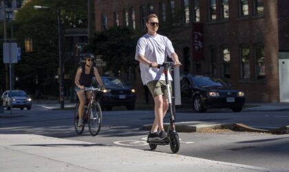 A man riding the GOTRAX G4 in a commercial area