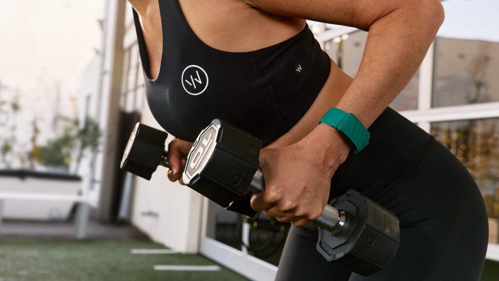 WHOOP 5.0 on a woman lifting weights